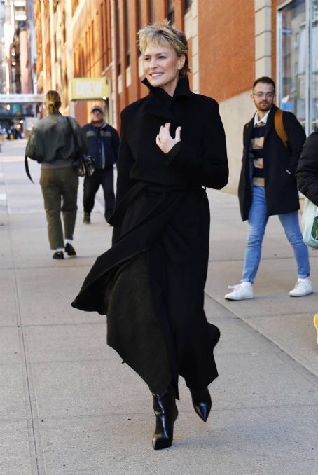 Robin Wright – In a black trench coat and knee long boots in New York