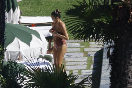 Chrissy Teigen – Seen by a swimming pool in Lake Como