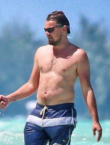 Leonardo DiCaprio goes shirtless while holding hands with his bikini-clad girlfriend Toni Garrn at the beach last week in Bora Bora. (April 14)