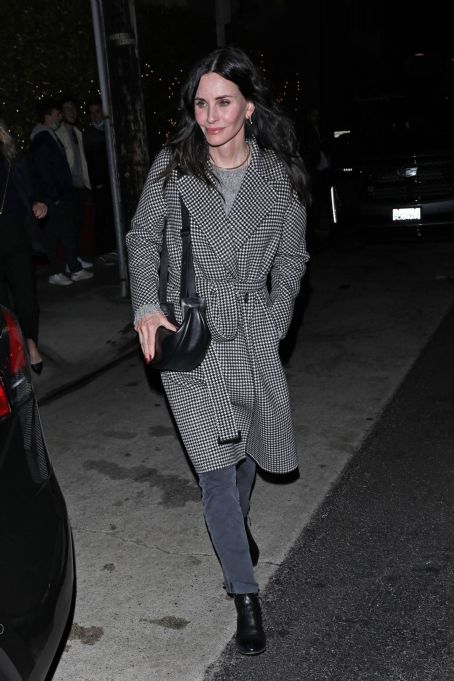 Courteney Cox – In a black and white long coat at Giorgio Baldi