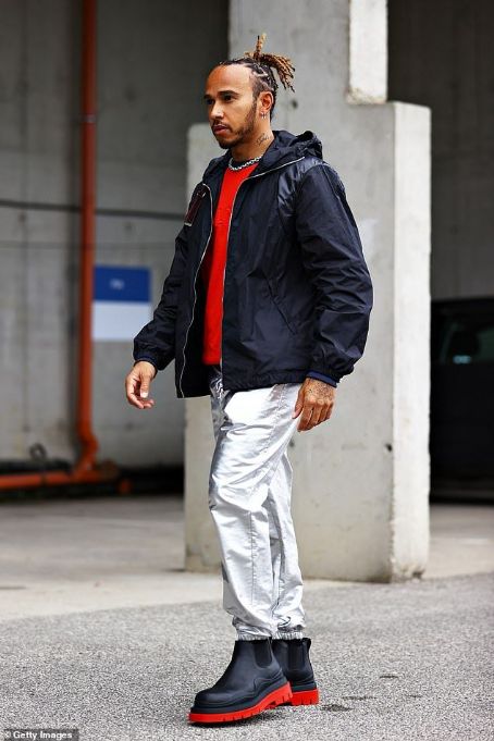 Lewis Hamilton turns heads in metallic silver Celine trousers and a red Balmain jumper ahead of his race in the Hungarian Grand Prix